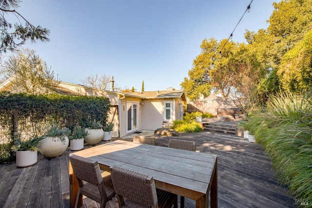 wooden deck featuring french doors and outdoor dining space