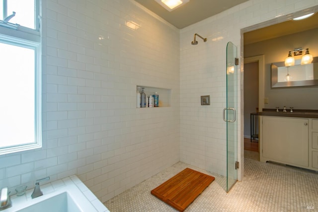 full bathroom featuring vanity, a bath, a shower stall, and tile patterned flooring