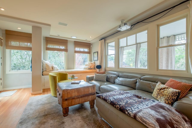 living area with recessed lighting, plenty of natural light, wood finished floors, and visible vents