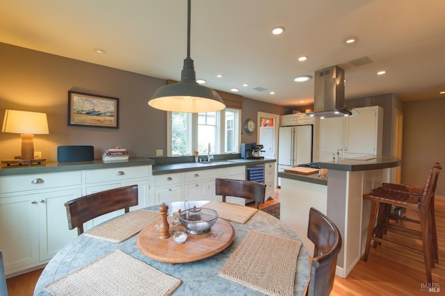 dining space featuring recessed lighting, wine cooler, and light wood-style floors