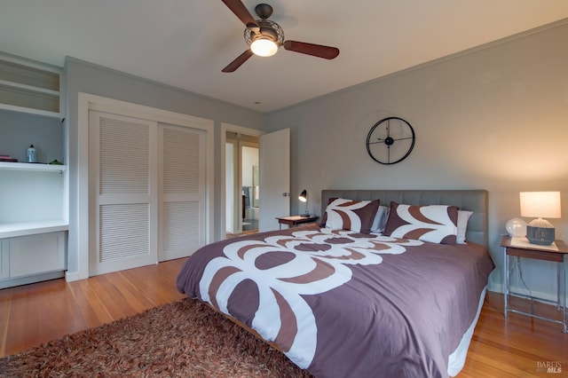 bedroom featuring a closet, baseboards, wood finished floors, and a ceiling fan