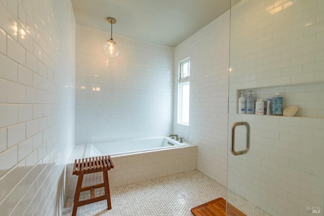 full bathroom with tile patterned flooring, tile walls, a bath, and tiled shower