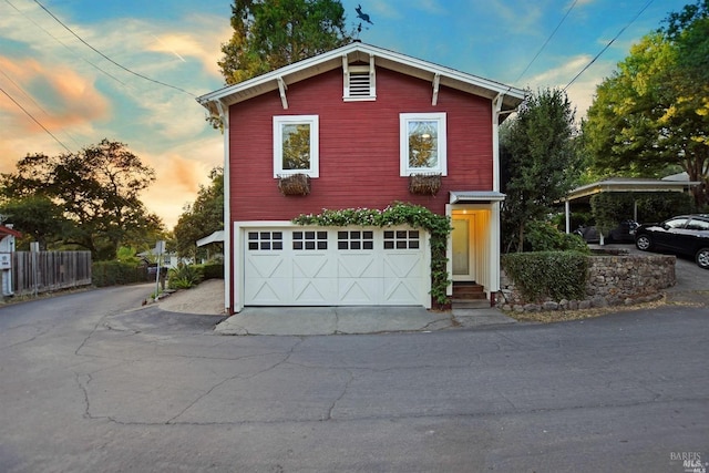 view of front of house with driveway, an attached garage, and fence