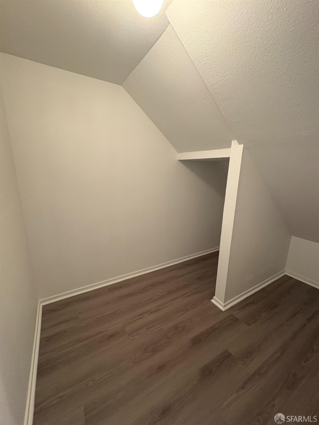 450 Carl St, San Francisco, CA 94117 - bonus room with lofted ceiling, dark wood-style flooring, and a textured ceiling