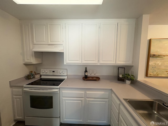 450 Carl St, San Francisco, CA 94117 - kitchen with white electric stove, under cabinet range hood, white cabinetry, and light countertops