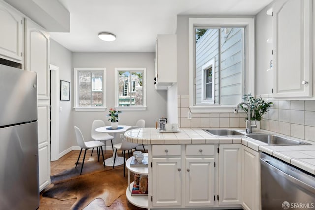510 11th Ave, San Francisco, CA 94118 - kitchen with appliances with stainless steel finishes, white cabinets, tile counters, and plenty of natural light
