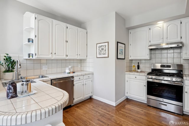 510 11th Ave, San Francisco, CA 94118 - kitchen featuring appliances with stainless steel finishes, under cabinet range hood, tile counters, wood finished floors, and open shelves