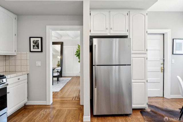 510 11th Ave, San Francisco, CA 94118 - kitchen featuring freestanding refrigerator, tile countertops, white cabinetry, and light wood finished floors