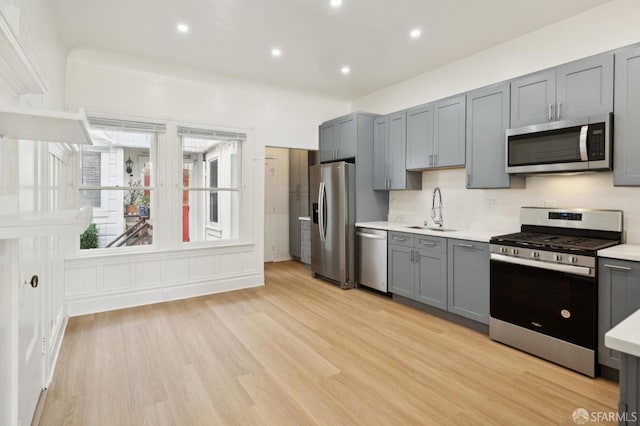 968-970 Broadway, San Francisco, CA 94133 - kitchen featuring appliances with stainless steel finishes, gray cabinets, light countertops, light wood-style floors, and recessed lighting