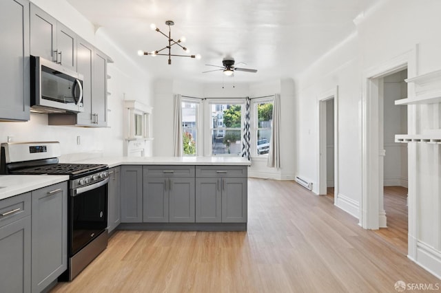 968-970 Broadway, San Francisco, CA 94133 - kitchen featuring appliances with stainless steel finishes, gray cabinets, a peninsula, a chandelier, and a ceiling fan