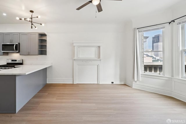 968-970 Broadway, San Francisco, CA 94133 - kitchen featuring appliances with stainless steel finishes, open shelves, light wood-type flooring, a chandelier, and gray cabinetry
