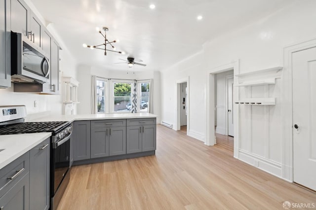 968-970 Broadway, San Francisco, CA 94133 - kitchen featuring appliances with stainless steel finishes, gray cabinets, a peninsula, a chandelier, and light wood-style floors