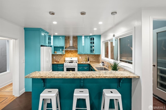 1871 Alemany Blvd, San Francisco, CA 94112 - kitchen with white appliances, blue cabinets, wall chimney exhaust hood, a peninsula, and recessed lighting