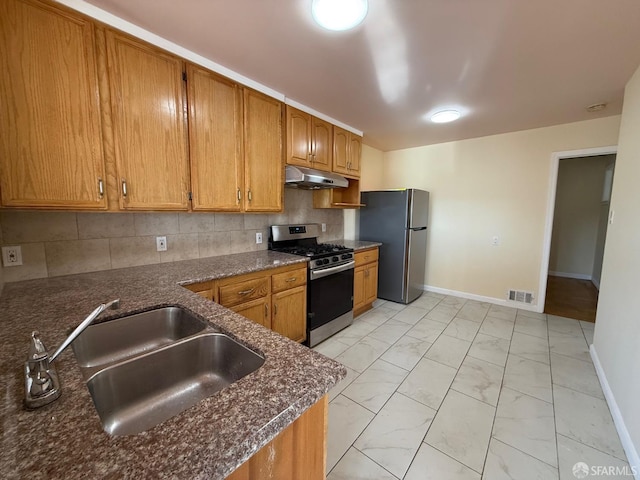 kitchen featuring sink, dark stone countertops, backsplash, kitchen peninsula, and stainless steel appliances