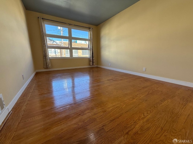 unfurnished room with hardwood / wood-style flooring