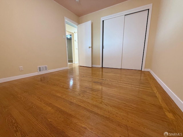 unfurnished bedroom with light hardwood / wood-style floors and a closet