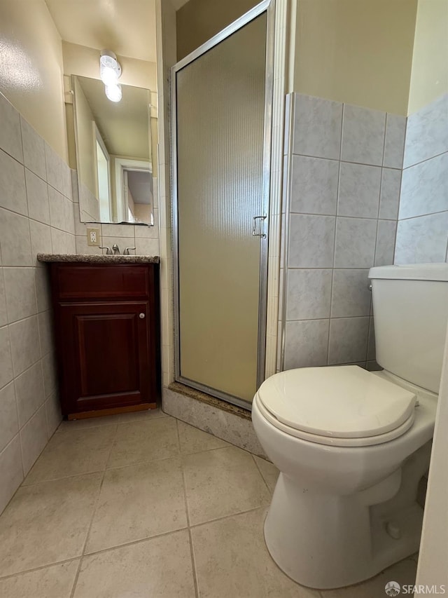 bathroom with tile patterned flooring, tile walls, an enclosed shower, and toilet