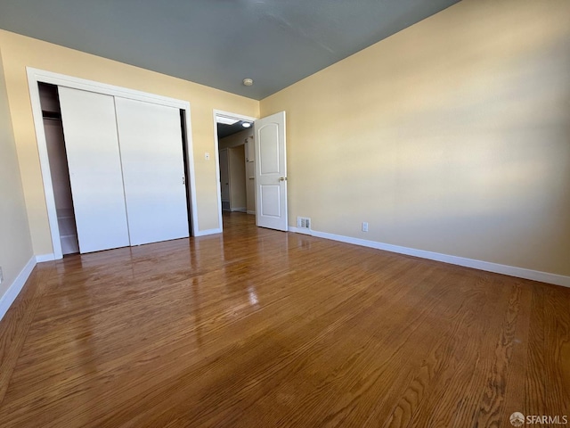 unfurnished bedroom featuring hardwood / wood-style floors and a closet