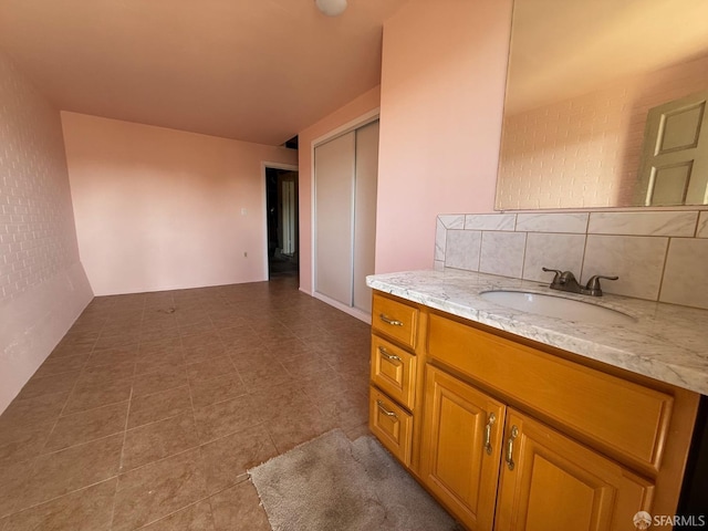 interior space featuring light stone counters, sink, and decorative backsplash