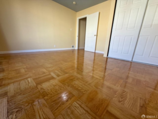 unfurnished bedroom with a closet and light parquet flooring