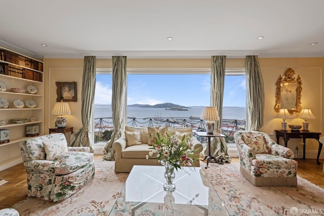 living room featuring a water view, light parquet flooring, ornamental molding, and built in features