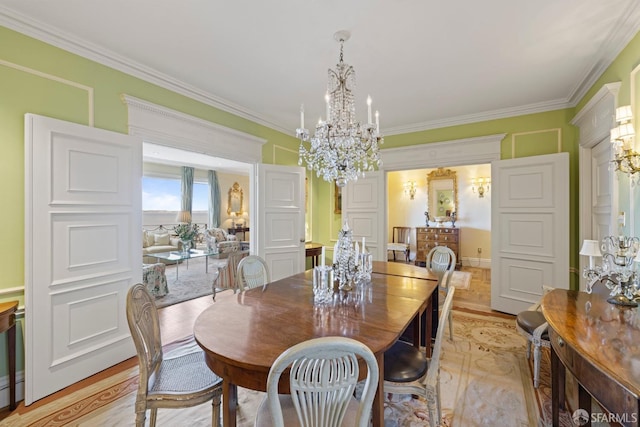 dining area with ornamental molding, a chandelier, and light hardwood / wood-style flooring