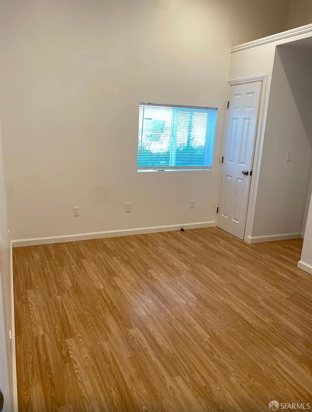 unfurnished room with light wood-style flooring and baseboards