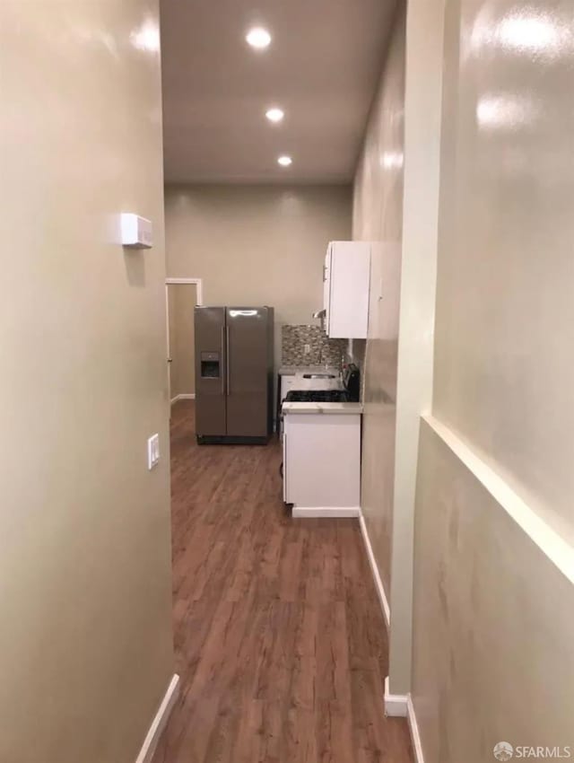 hall featuring recessed lighting, dark wood-style floors, and baseboards