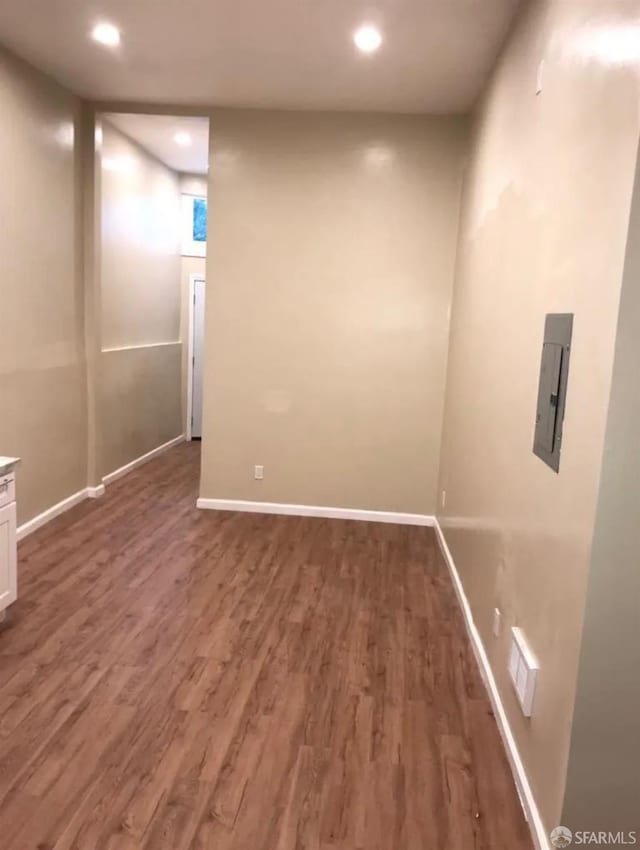 empty room featuring recessed lighting, baseboards, and wood finished floors