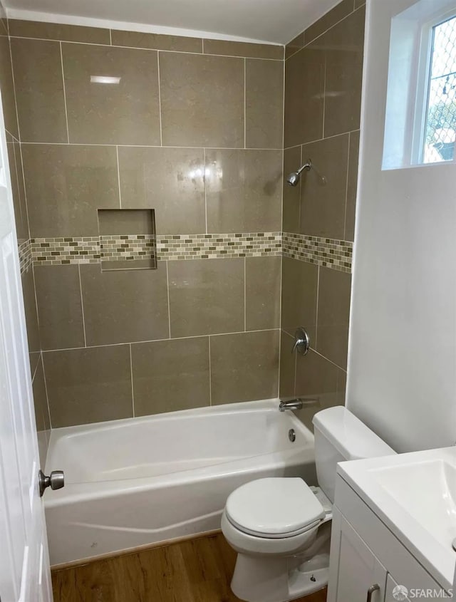 bathroom featuring vanity, toilet, wood finished floors, and shower / bath combination