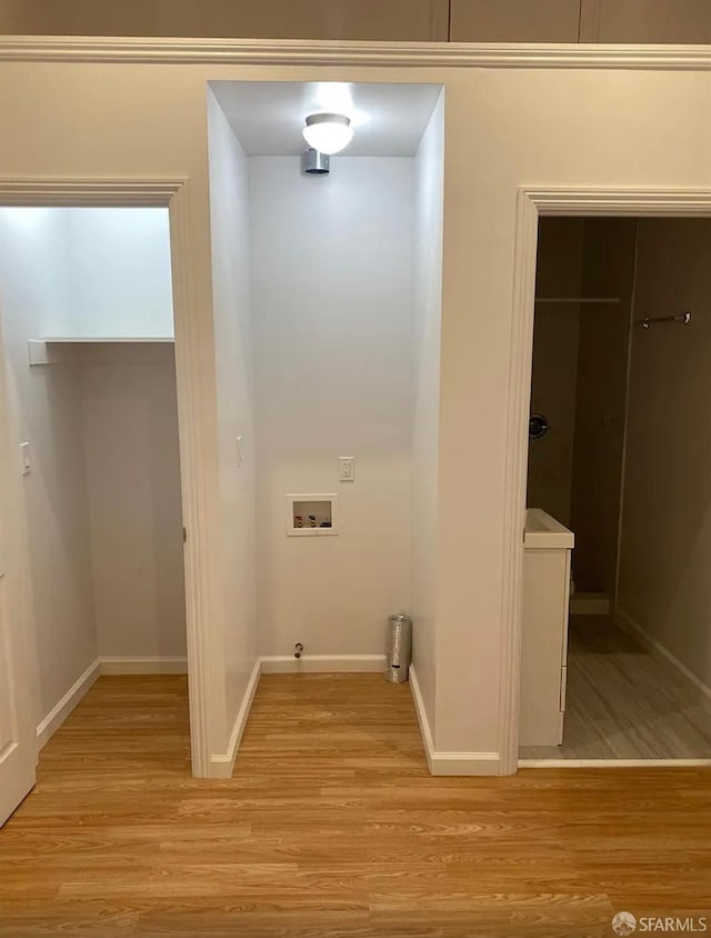 washroom with laundry area, light wood-style flooring, baseboards, and washer hookup