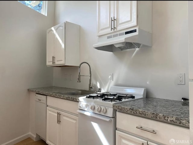 kitchen with baseboards, under cabinet range hood, white cabinets, white appliances, and a sink