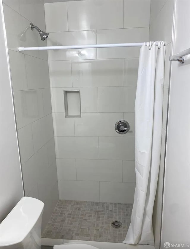 full bathroom featuring toilet and a stall shower