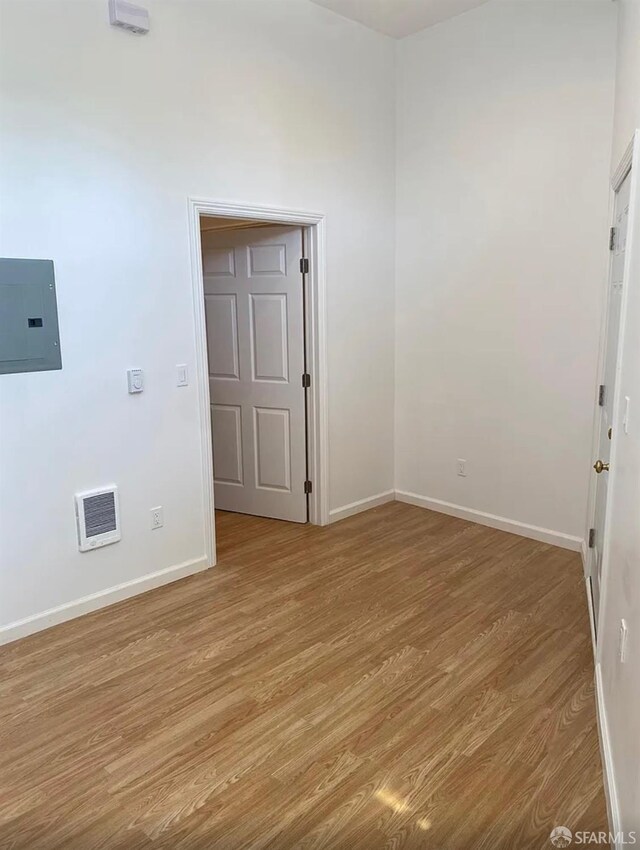 spare room with light wood finished floors, visible vents, and baseboards