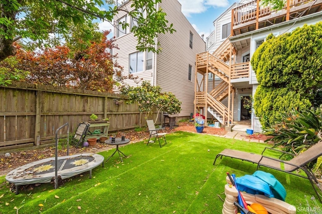 view of yard with fence and stairway