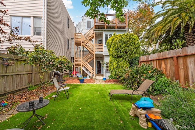 back of house with stairway, a fenced backyard, and a lawn