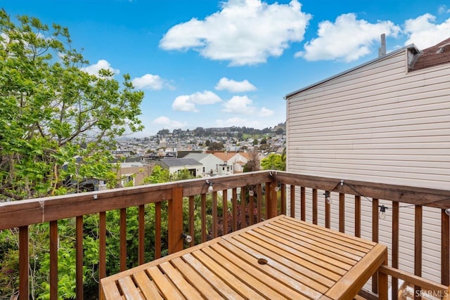 wooden terrace featuring outdoor dining area and a residential view