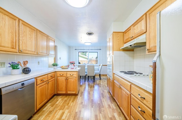 kitchen with tile countertops, backsplash, kitchen peninsula, white appliances, and light hardwood / wood-style flooring