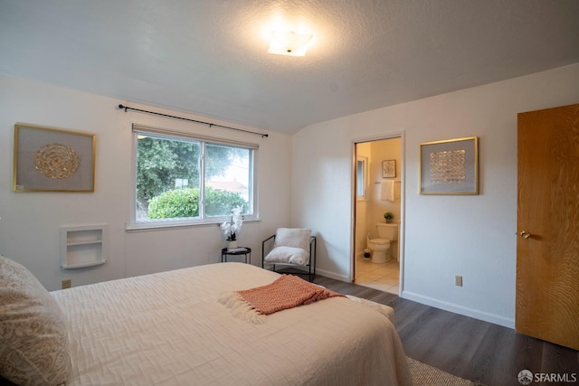 bedroom featuring light hardwood / wood-style flooring, a textured ceiling, and ensuite bathroom