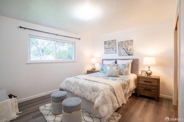 bedroom with dark hardwood / wood-style flooring and a textured ceiling