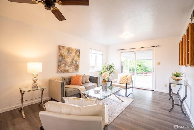 living room with dark wood-type flooring and ceiling fan