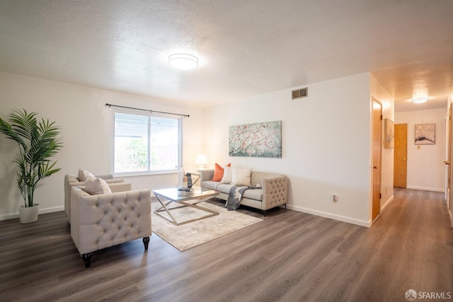 living room with dark wood-type flooring and a textured ceiling