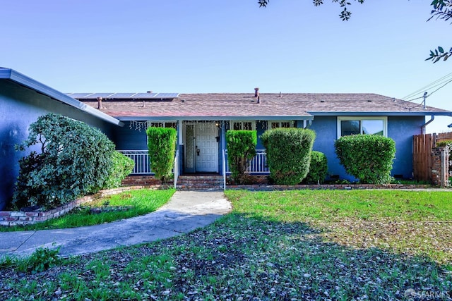 ranch-style home featuring a front lawn and solar panels