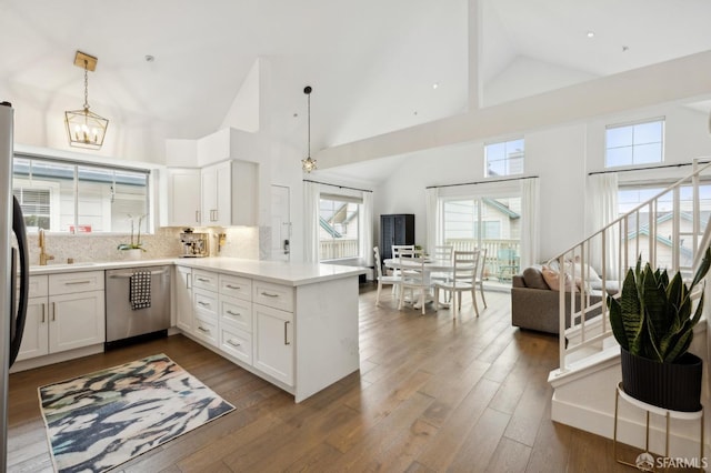 kitchen with stainless steel dishwasher, white cabinets, and kitchen peninsula