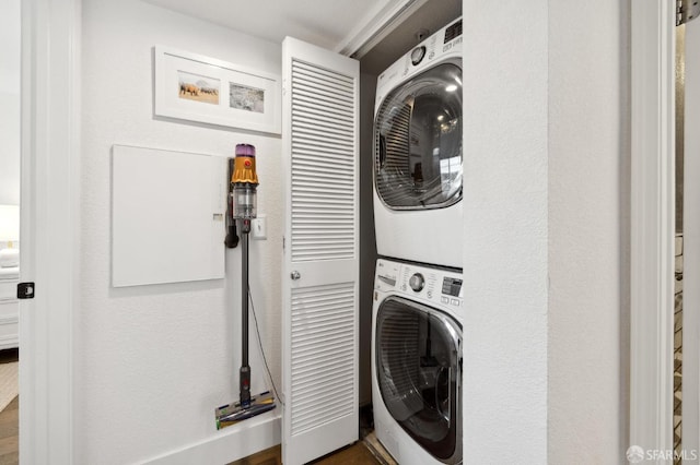 clothes washing area with stacked washer / dryer