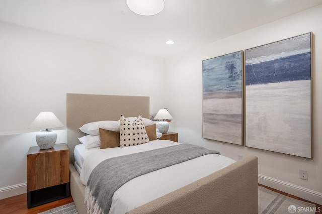 bedroom with baseboards, wood finished floors, and recessed lighting