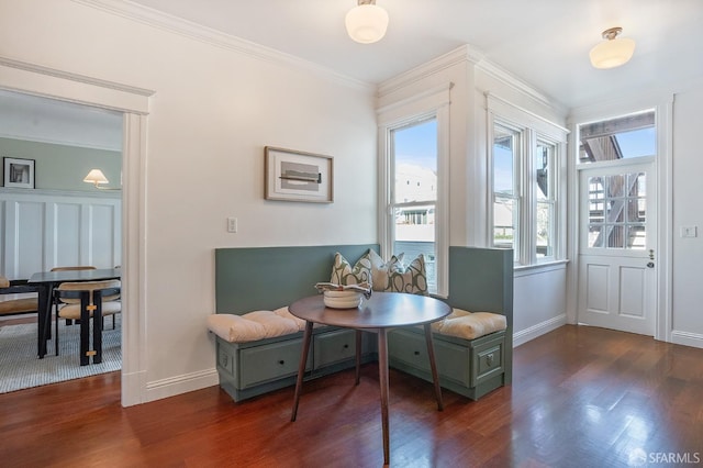 dining space with baseboards, wood finished floors, and crown molding