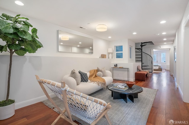 living area featuring baseboards, visible vents, wood finished floors, and recessed lighting