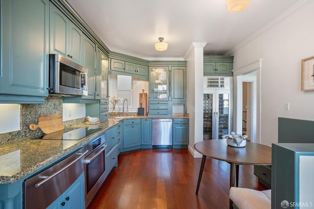 kitchen with crown molding, backsplash, appliances with stainless steel finishes, dark wood-type flooring, and a sink