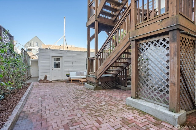 view of patio with stairs and an outbuilding